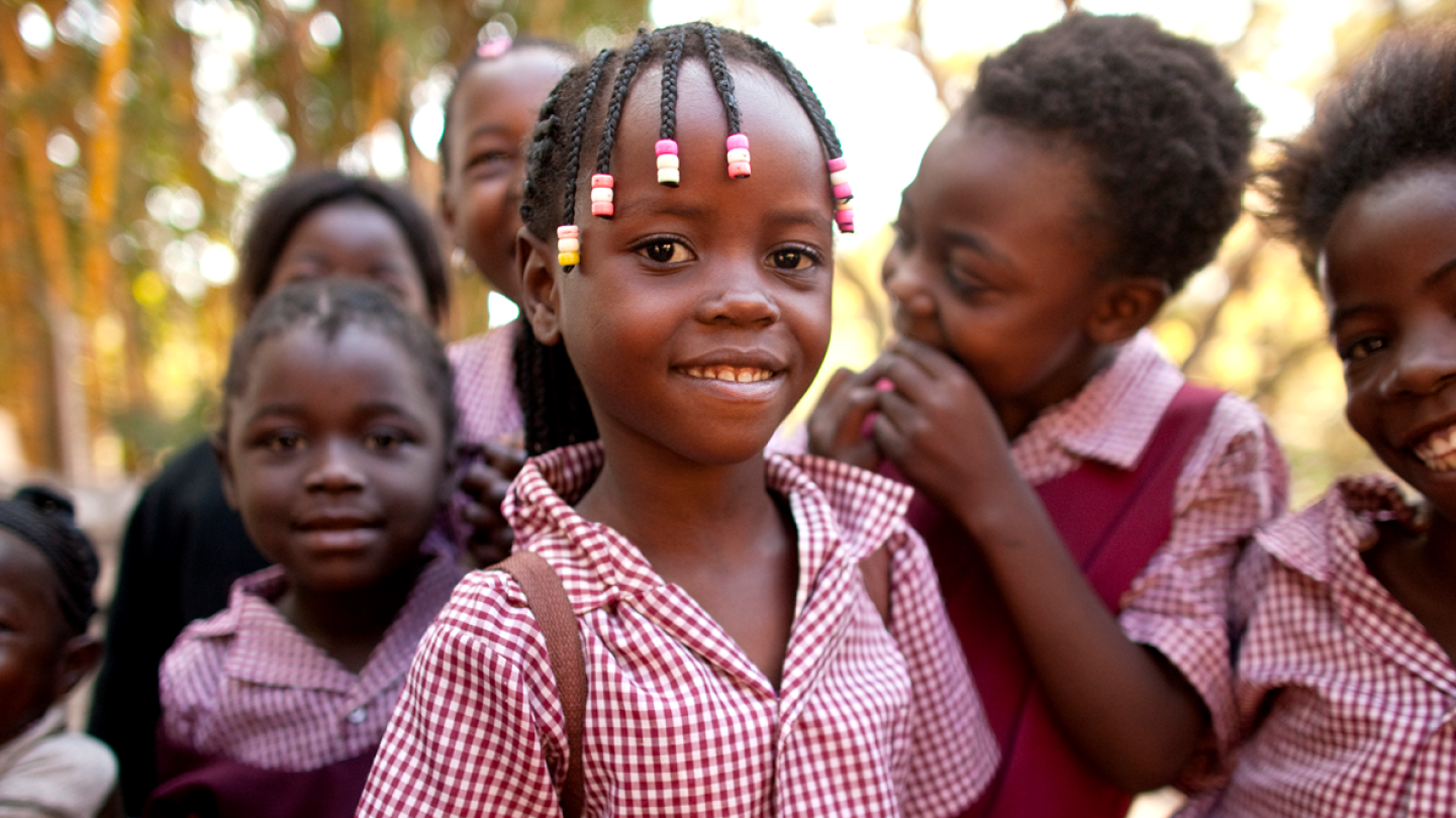 Group of kids in matching uniforms smiling and laughing 