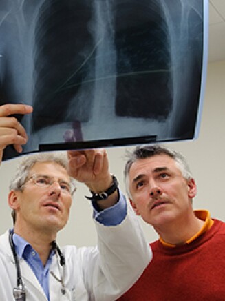 physician and patient looking at an x-ray scan
