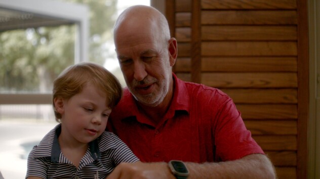 John and his young grandson doing a puzzle at the kitchen table
