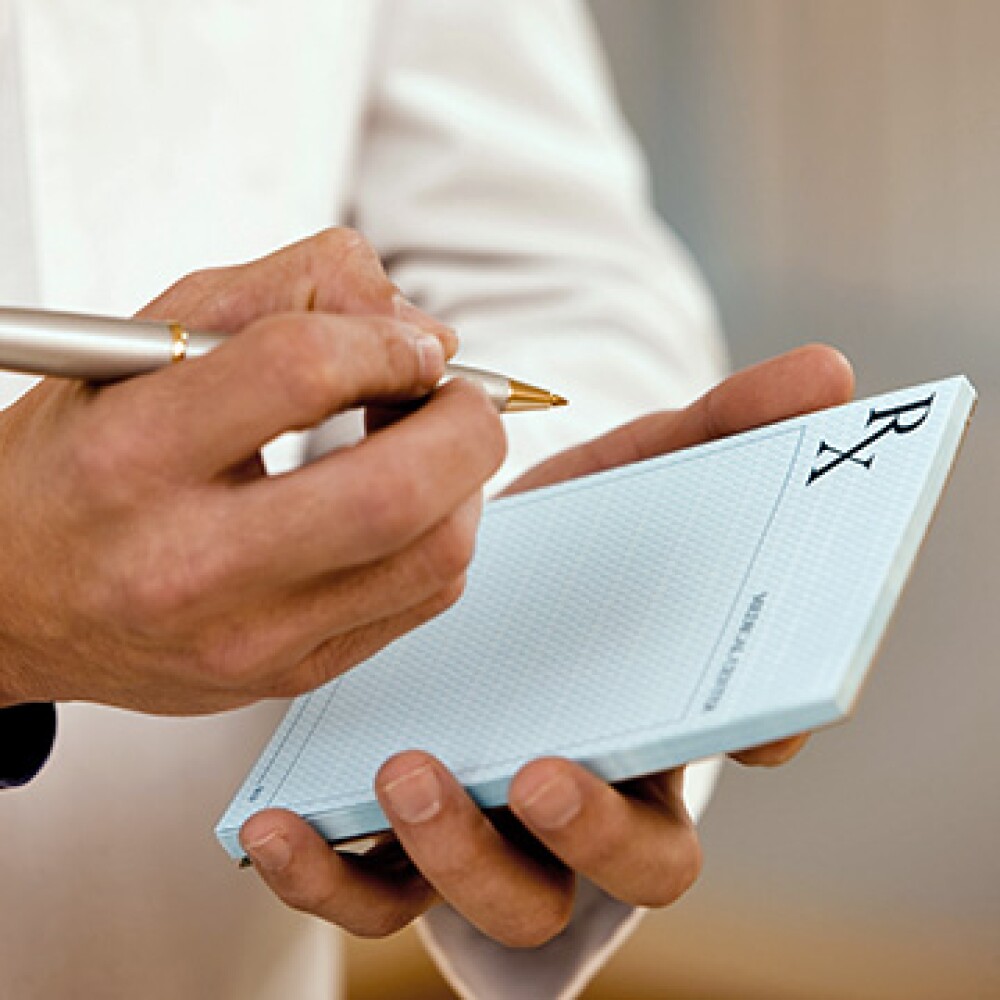 A doctor writing down a prescription for a patient