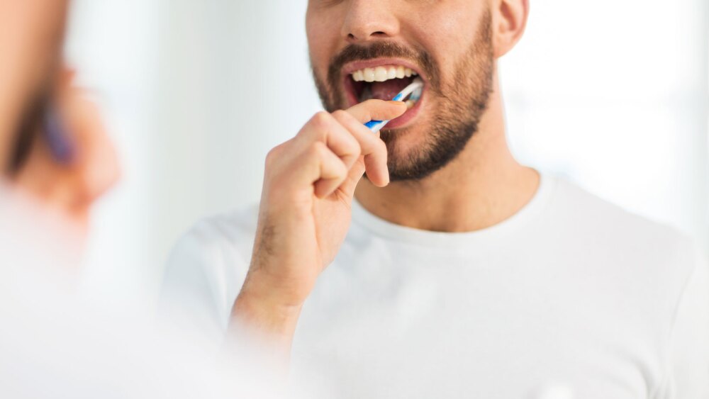 man brushing his teeth