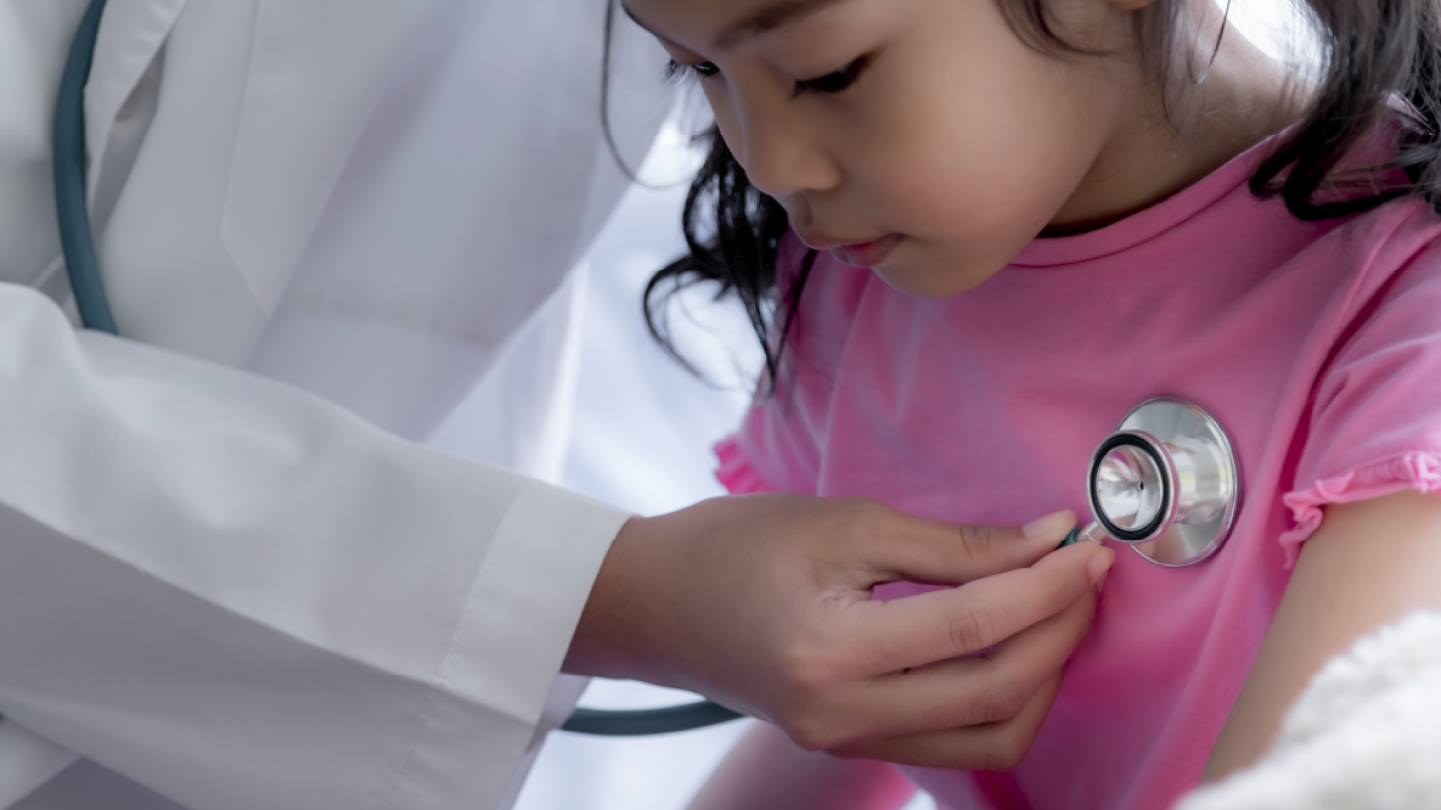 Doctor listening to a little girl's heartbeat with a stethoscope 