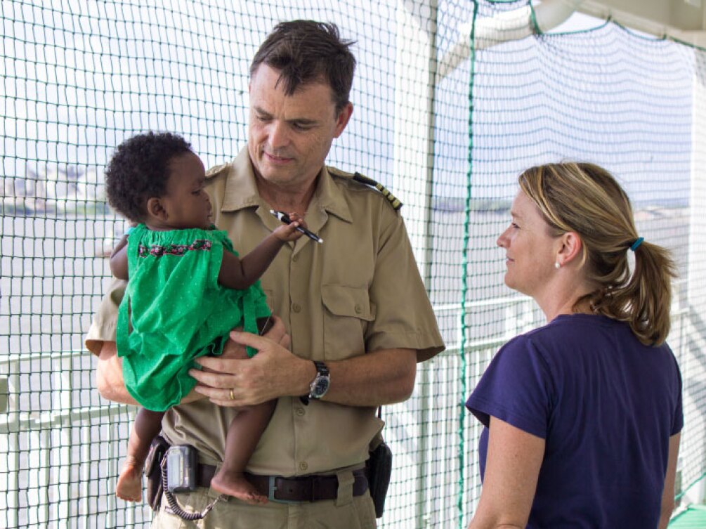 Lee-Anne and husband John holding a child abroad a Mercy Ship