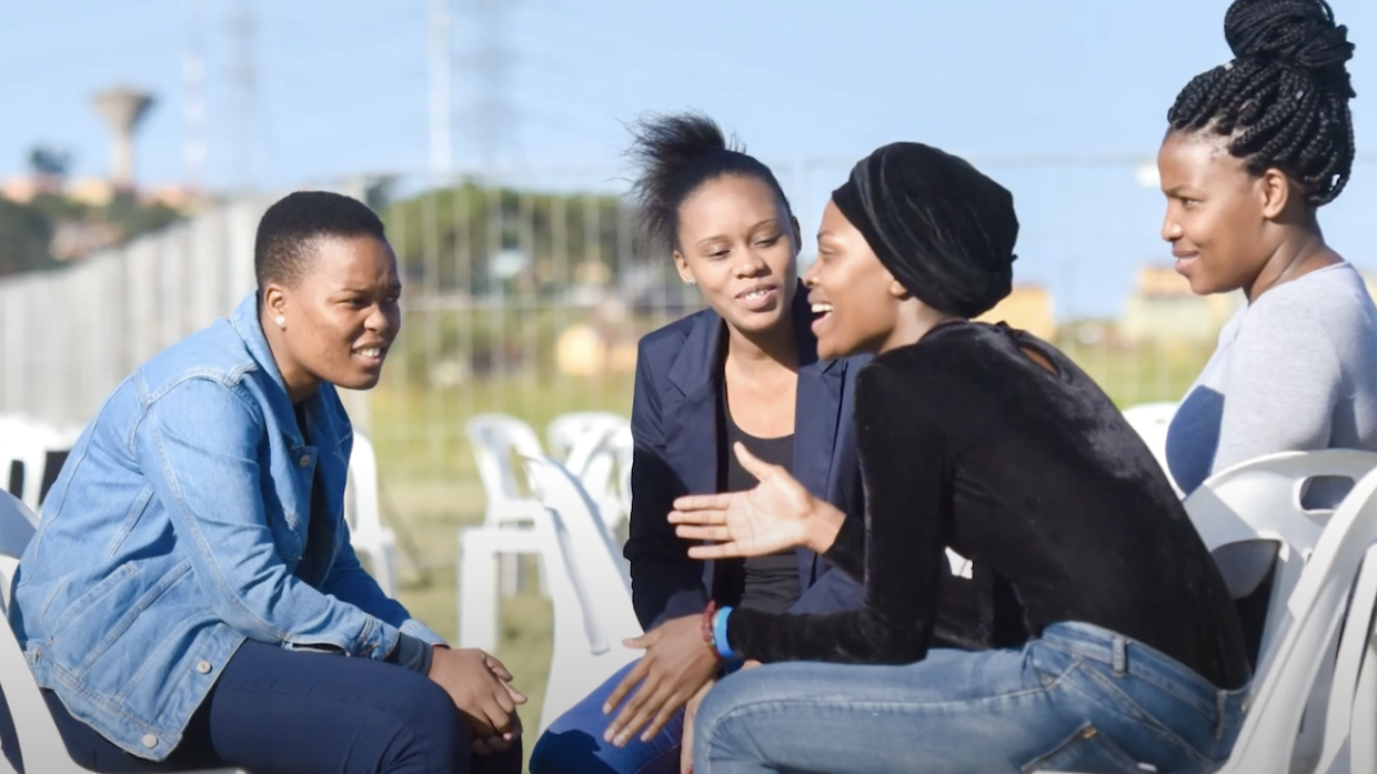 Four teenagers talking in a circle