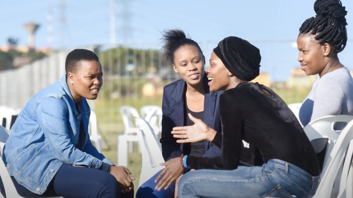 Four teenagers talking in a circle 