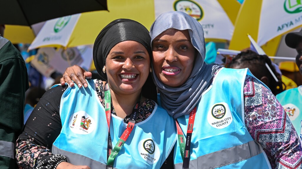 Two healthcare workers pose for a photo at community event in Nairobi, Kenya