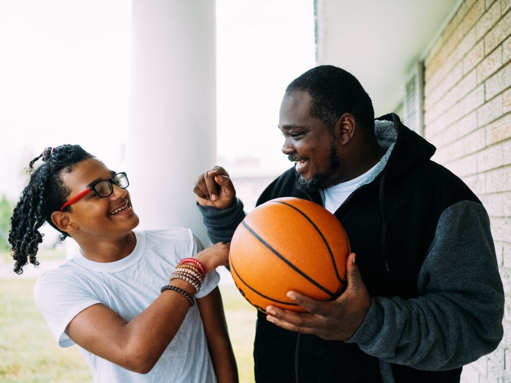 A man and his son playing with a basketball