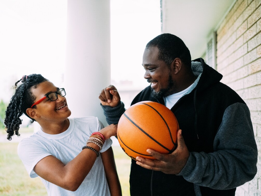 A man and his son playing with a basketball 