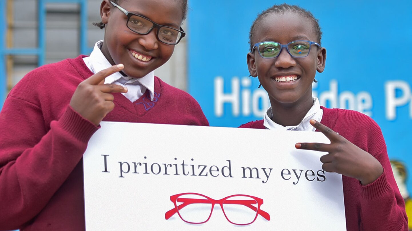 Students in glasses holding a sign that reads "I prioritized my eyes" 