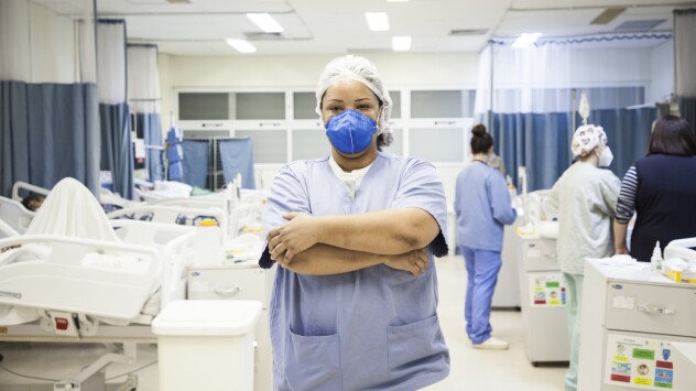 A woman in surgical scrubs in the middle of a hospital room