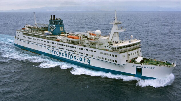 Aerial view of a Mercyships.org floating hospital ship sailing through the ocean