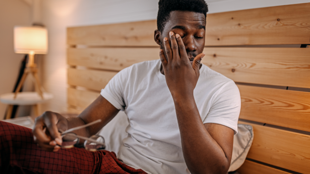 Man holding his left eye in discomfort due to dry eye disease symptoms