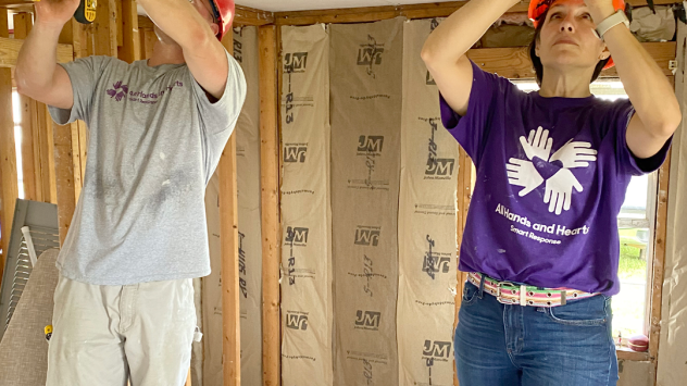 Johnson & Johnson employee Mafalda Klitsch volunteers installing a ceiling in a rebuilt house.