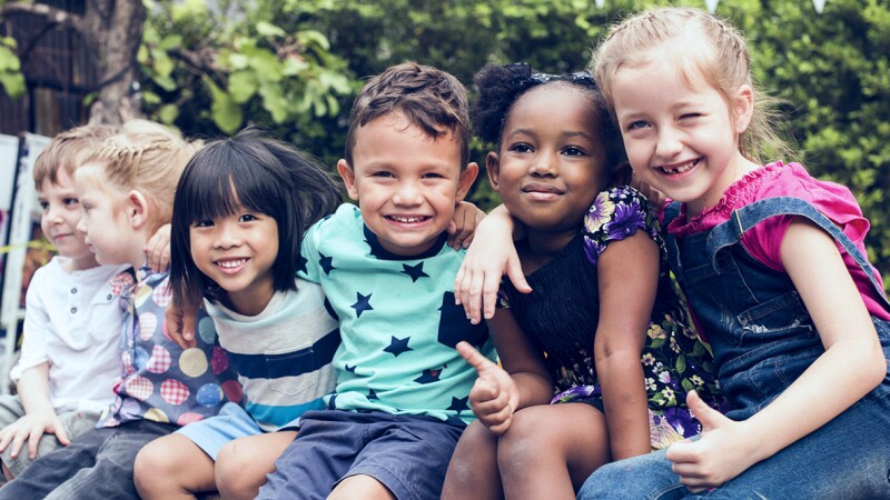 Children sitting on a bench smiling