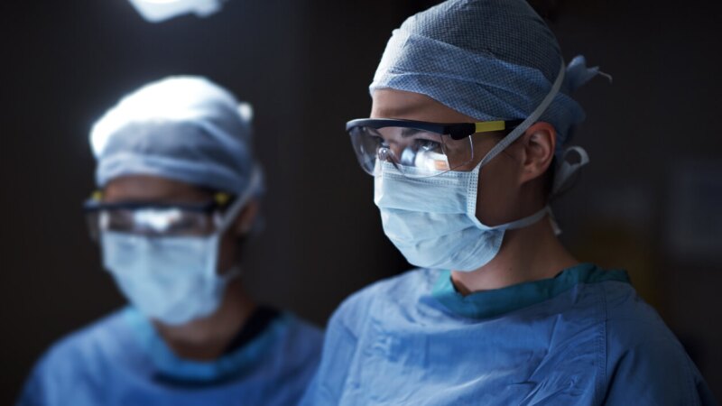 two medical professionals in a surgical setting